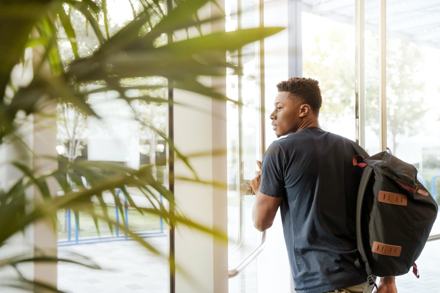 un étudiant pousse la porte de son université